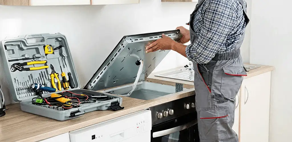 Handyman repairing a cooktop and checking wiring connections in New Haven, CT