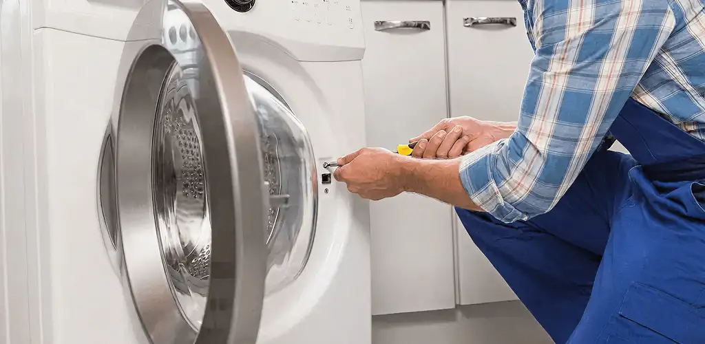 Handyman repairing a clothes dryer and checking electrical connections in New Haven, CT