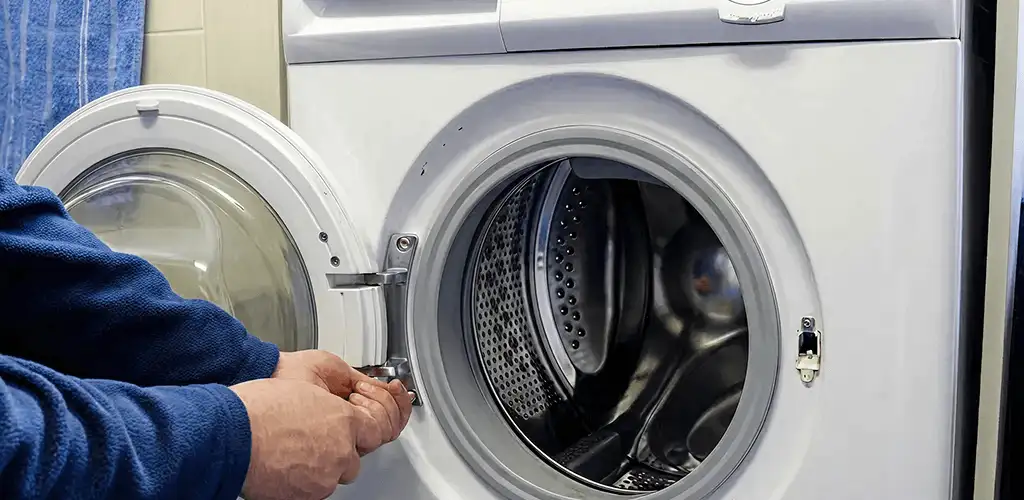 Washing machine repair handyman checking a front-load washer door and latch in New Haven, CT