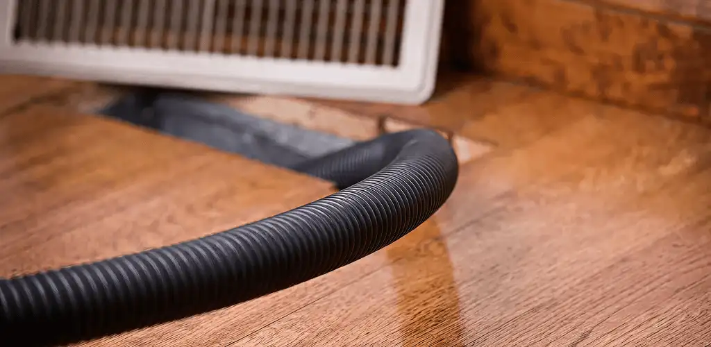 Air duct cleaning hose inserted into a floor vent for ductwork cleaning in New Haven, CT