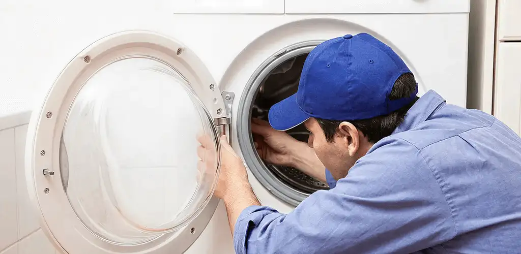 Washing machine repair handyman inspecting a front-load washer drum in New Haven, CT